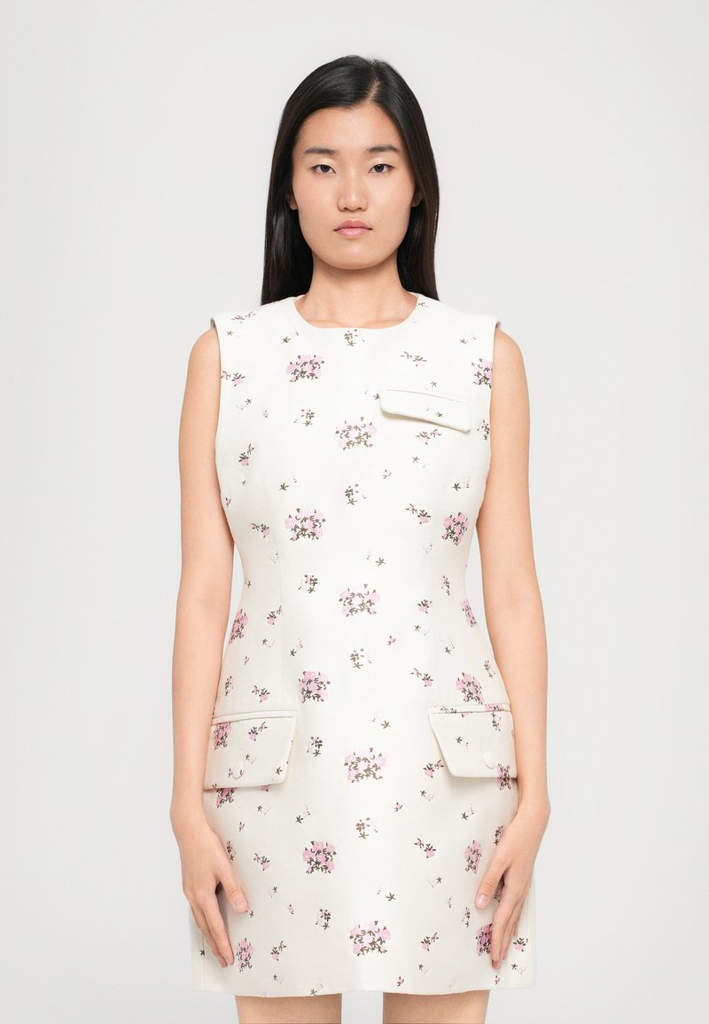 Kreemivärvi lilledega mustriga ilma varrukateta kleit, kus on väikesed roosad lilled, kaks esist taskut ja lihtne ümmargune kaelus.