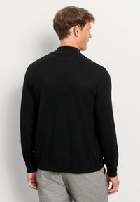 Schwarze Strickjacke mit Kragen, langen Ärmeln, gerippten Bündchen und Saum. Sie hat eine glatte Textur und ist für eine figurbetonte Silhouette konzipiert.
