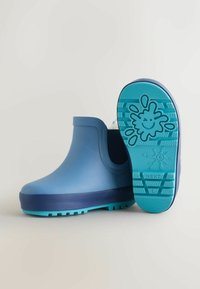 Stivali impermeabili per bambini alla caviglia di colore azzurro chiaro con suola blu scuro. Esterno in gomma testurizzata e suola con motivo per una migliore aderenza.