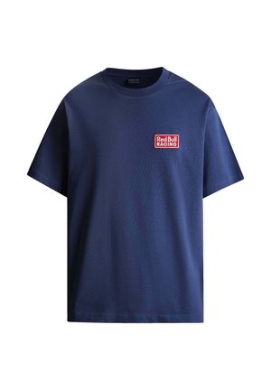 Mörkblå t-shirt i bomull med korta ärmar, med en rektangulär röd och vit "Red Bull Racing"-logotyp på vänster bröst.