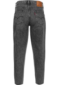 Musta korkeavyötäröinen Levi's-farkut, joissa on kaksi takataskua, punainen Levi's-tunnus ja ruskea nahkapaikka vyötäröllä.