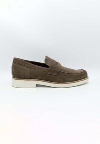 Mocassins en daim marron avec un détail cousu sur le devant, dotés d'une semelle en caoutchouc blanc. Texture lisse et design classique à enfiler.