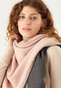 Lichte sjaal in roze en grijs. Zachte textuur met een gladde afwerking. Voorzien van een contrasterende steek langs de randen.