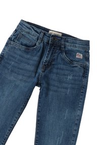 Vaqueros de mezclilla azul oscuro con un acabado desgastado, que presentan un cierre con cremallera, pasadores para cinturón, bolsillos frontales y una etiqueta de la marca en el bolsillo trasero.