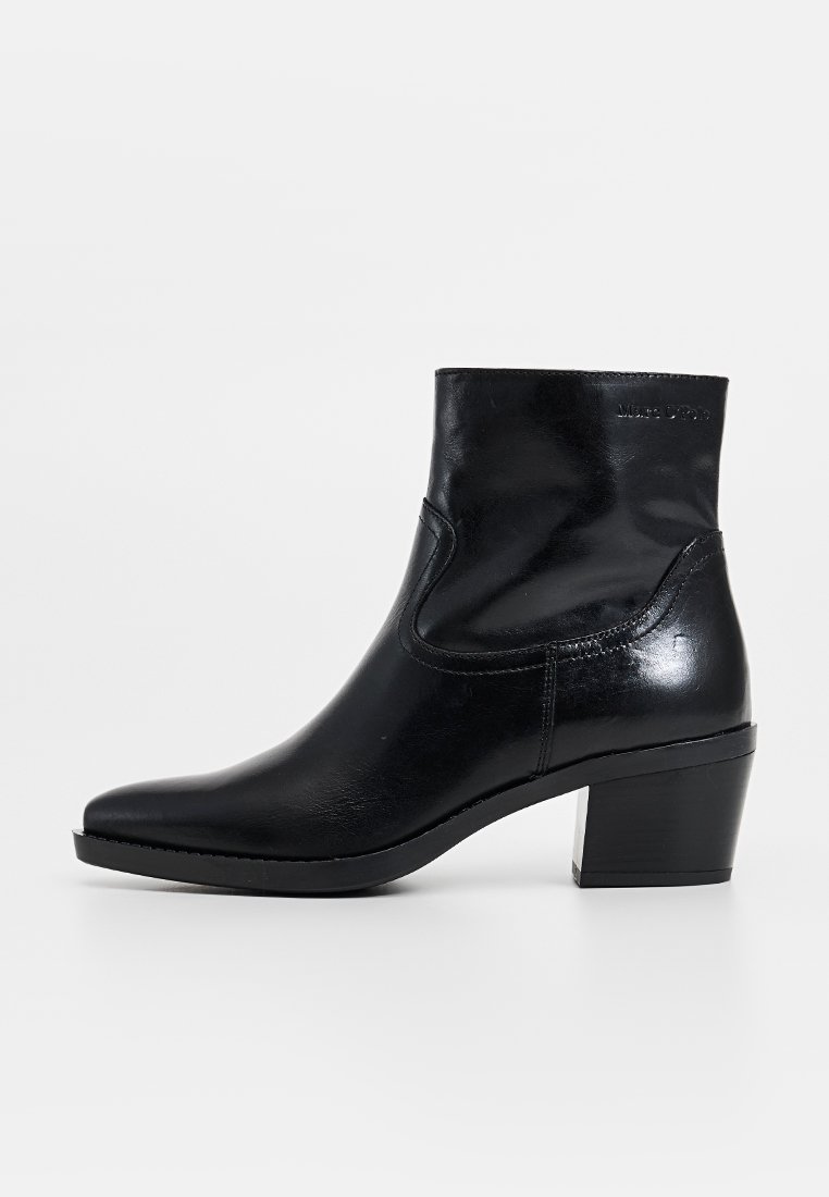 Bottes chelsea en cuir noir avec un bout pointu et un design épuré. Dotées d'un talon bloc et de panneaux latéraux élastiques pour un enfilage facile.