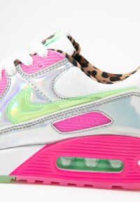 Tenisky Nike Air Max mají stříbrný iridescentní svršek, růžové akcenty, zelené detaily a podšívku s leopardím vzorem.