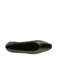 Botte plate en cuir noir avec un bout pointu, texture lisse et sans matériel visible. L'intérieur est non doublé avec un design simple et épuré.