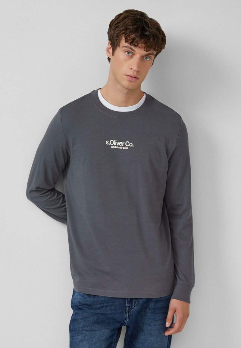 Graues Langarmshirt mit runder Ausschnitt, mit weißem gesticktem Logo "s.Oliver Co. Established 1969" auf der Brust. Klassischer Schnitt.