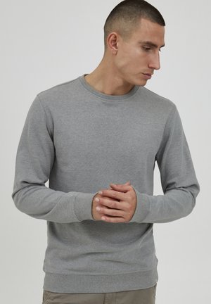 Gray cotton sweatshirt with a crew neckline, ribbed cuffs, and hem. Soft texture, medium weight, fits close to the body. No visible logos.