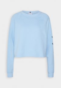 Jasnoniebieski krótki sweatshirt z raglanowymi rękawami, ściągaczami oraz haftowanymi detalami na rękawie; miękka tekstura, casualowy styl.