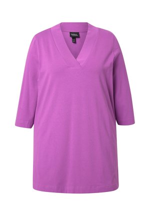Fioletowa koszulka z dekoltem w serek, z rękawami o długości trzech ćwierć, wykonana z gładkiego materiału, o luźnym kroju i prostym mankiecie. Brak widocznych wzorów lub elementów metalowych.