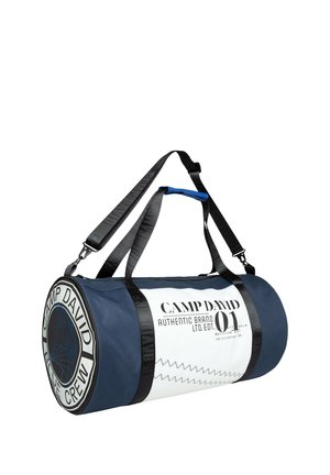 Blue and white duffel bag with black straps, featuring rounded shape, logo print, and zigzag stitching detail. Durable fabric construction.