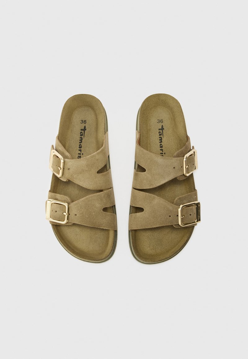 Bruna sandaler med två justerbara spännen, utformade för komfort, visade mot en enkel vit bakgrund. Storlek 36 angiven.