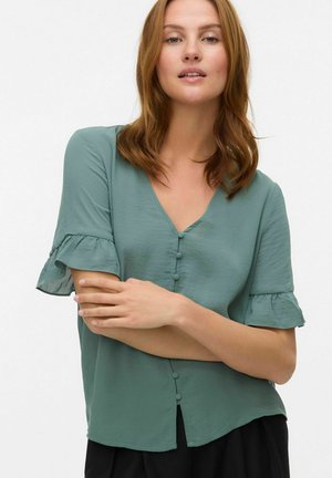 Blouse mint vert à manches courtes avec un col en V, doté d'une fermeture à boutons sur le devant et de manches volantes en tissu léger et doux.