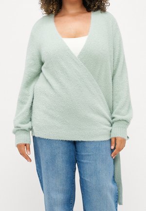 Weicher, hellgrüner Wickelpullover mit langen Ärmeln und tiefem V-Ausschnitt. Mit strukturiertem Strick und seitlichen Details, die unter die Taille reichen.
