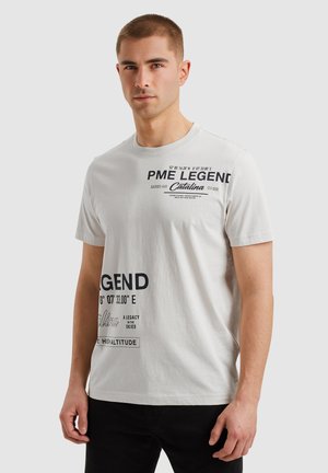 White cotton t-shirt featuring navy text graphics, crew neckline, and short sleeves. Displays geographic coordinates and brand name prominently.