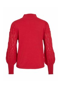 Pull rouge avec un corps uni et des manches bouffantes à texture et motifs. Le col et les poignets côtelés accentuent le design.