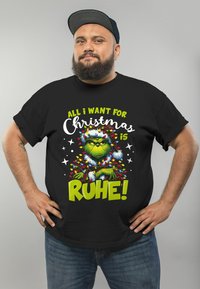 Black t-shirt featuring a colorful Grinch graphic, adorned with Christmas lights and text: "All I want for Christmas is RUHE!"