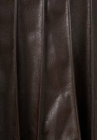 Falda de cuero sintético marrón oscuro con textura, plisados verticales y un brillo sutil. Presenta costuras visibles y bordes lisos.