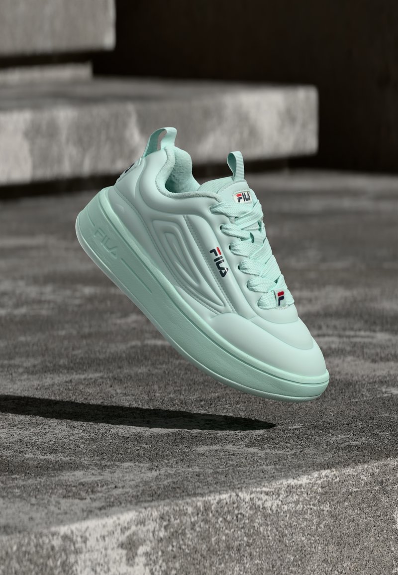 Αθλητικό παπούτσι σε χρώμα aqua με κομψό σχεδιασμό, που διαθέτει υλικό συνθετικό με υφή, κλείσιμο με κορδόνια και λεπτές διακριτικές λεπτομέρειες λογότυπου στο πλάι.