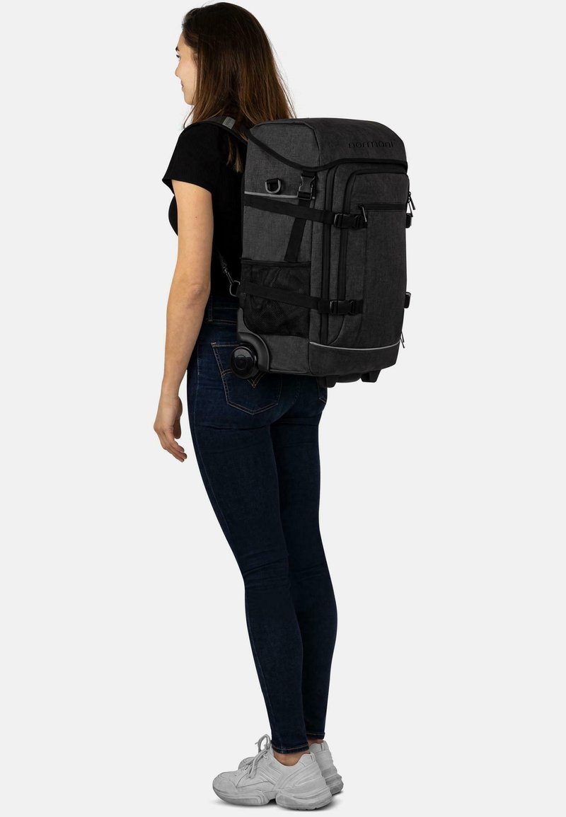 Schwarzer Stoff-Rucksack mit mehreren Fächern, verstellbaren Trägern und einem ausziehbaren Griff. Verfügt über eine seitliche Netztasche und Rollen.