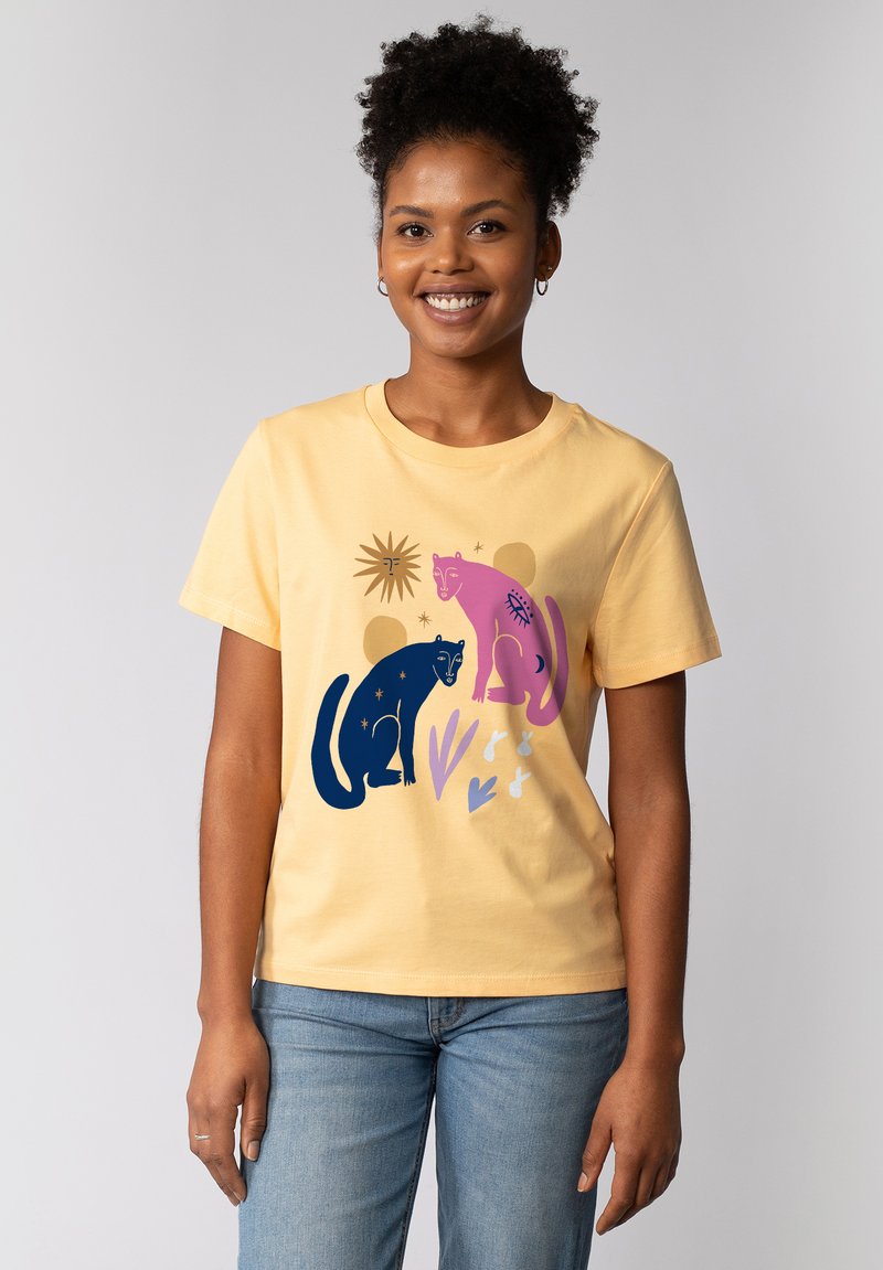 Gele katoenen t-shirt met een grafisch ontwerp van een zwarte en roze panter tussen abstracte vormen en lijnen. Korte mouwen en ronde hals.