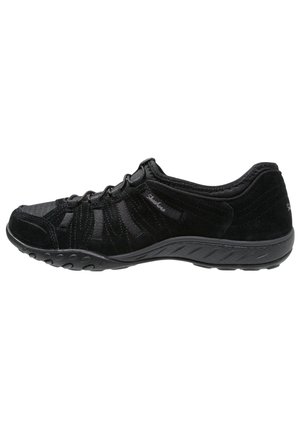Czarny niskoprofilowy sneaker z przednią sznurowadłą, teksturowaną podeszwą i miękką cholewką z tkaniny z subtelnym logo marki po boku.