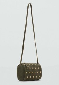Borsa a tracolla in suede verde oliva con chiusura a zip, forma cilindrica e accenti circolari dorati distribuiti uniformemente sulla parte frontale.