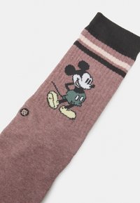 Calze di Topolino in morbido tessuto mauve. Presentano una banda nera nella parte superiore con strisce rosa e crema e un design colorato del personaggio.