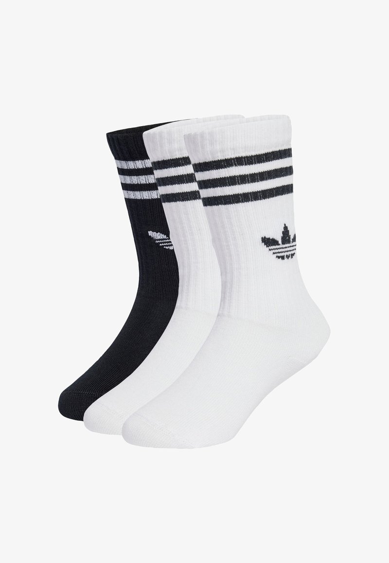 Tri páry ponožiek do členkov v čiernej a bielej farbe, s dvoma čiernymi pruhmi na vrchu a logom na každej ponožke. Vyrobené z texturovaného materiálu.