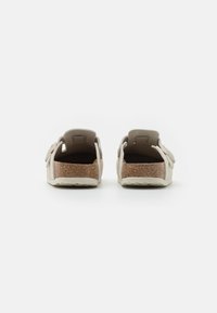 Kurkzolen sandalen met lichtbeige synthetische banden, open achterkant ontwerp en verstelbare gespen aan de bovenkant voor een veilige pasvorm. Geweven oppervlak.