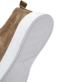 Brązowe zamszowe sneakersy z białą gumową podeszwą, charakteryzujące się teksturowanym spodem i materiałowym uchwytem; przeszycia wzdłuż górnej krawędzi.