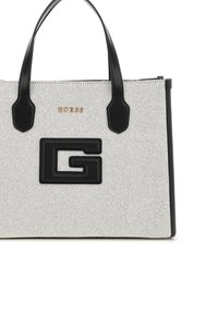 Torba tote w biało-czarnym tłoczeniu z podwójnymi uchwytami, z czarnym plastikowym logo i złotym napisem "GUESS" z przodu.