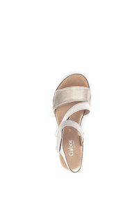 Beige sandalen met zachte stoffen banden, een gevoerde binnenzool, een open teenontwerp en een minimalistische stijl. Merklabel zichtbaar aan de binnenkant.