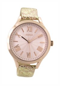 Montre en or rose avec un cadran rose texturé, des chiffres romains et un bracelet en cuir de serpent vert. Présente un boîtier rond et une couronne.