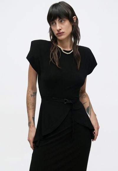 Czarna sukienka z krótkimi rękawkami typu kopertowego, dopasowany fason i talią podkreśloną paskiem. Gładka faktura z płynnie opadającym materiałem.