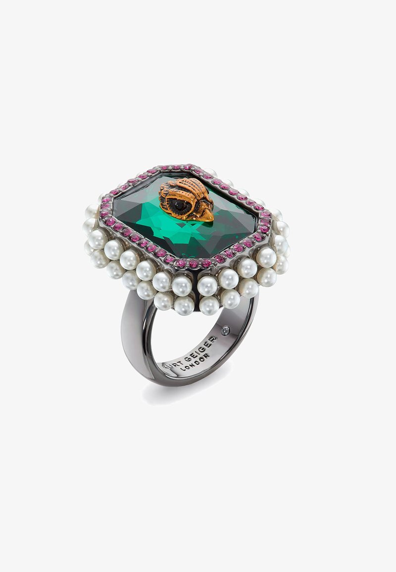 Hexagonal ring with a green gemstone, small skull design, surrounded by pink stones and white pearls, set in a dark metal band.