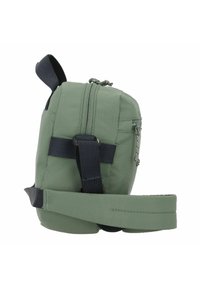 Green nylon crossbody bag with a zip closure, adjustable strap, side pocket, and textured surface. Compact and rectangular shape.