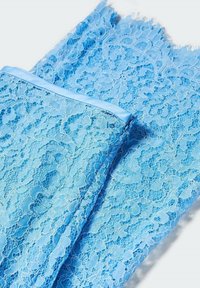 Lichtblauwe kantstof met een delicate bloemenpatroon. De randen zijn rafelig en er loopt een gladde blauwe satijnen riem langs één kant.