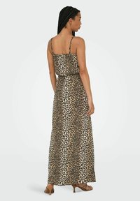 Maksi haljina s leopard uzorkom, tankim podešavanim naramenicama, strukom koji se skuplja i glatkom tkaninom; sadrži zemljane tonove smeđe i krem.