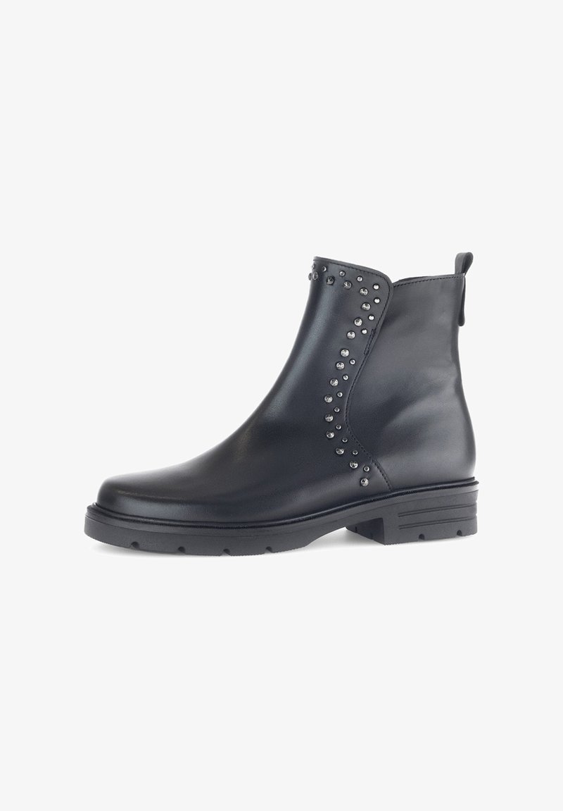 Bottine noire en cuir lisse, ornée de clous décoratifs sur le côté, avec un petit talon bloc et une languette à l'arrière.