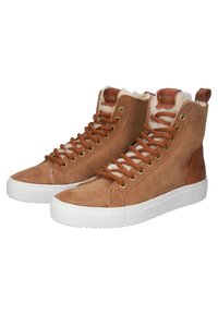 Ruske nubuk lisääntyy korkeakorkoiset tennarit, joissa on kermaiset vuoraukset, ruskeat nauhat, kultaiset silmäkappaleet ja valkoinen kumipohja. Logo-tagi kielen päällä.