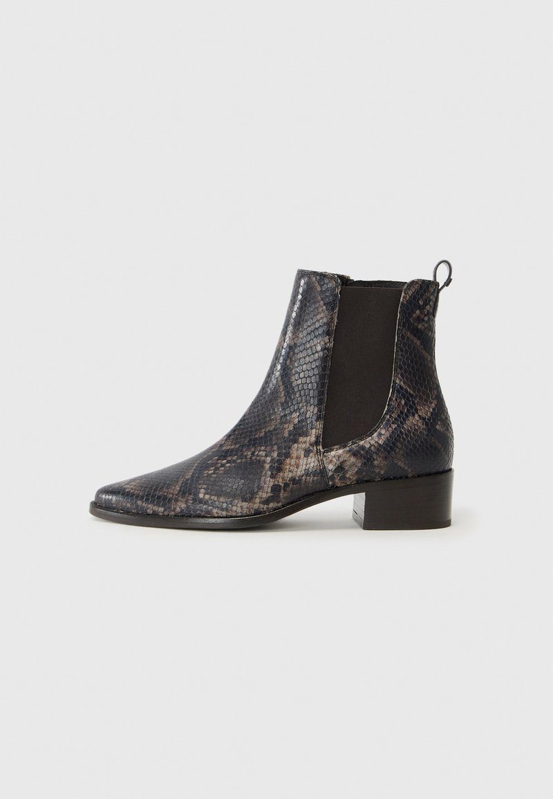 Botines de tobillo en estampado de serpiente en negro y gris, con punta afilada, paneles elásticos en los lados y un tacón bajo cuadrado. Patrón de reptil texturizado en todo.