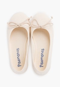 Ballet flats en toile beige avec un bout rond et un détail de nœud. La doublure intérieure est beige, et le nom de la marque "Pisamonas" est brodé en bleu.