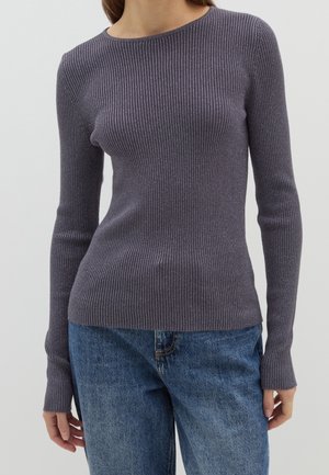 Paarse geribbelde lange mouw top met een ronde halslijn en een aansluitende pasvorm, gecombineerd met blauwe denim jeans.