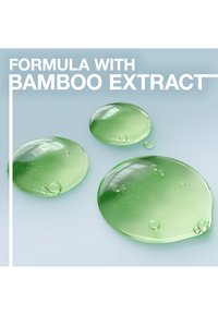 Gröna gel-droppar med bubblor på en ljusblå bakgrund, märkt "Formula med bambuextrakt." Slät textur och rundade former.
