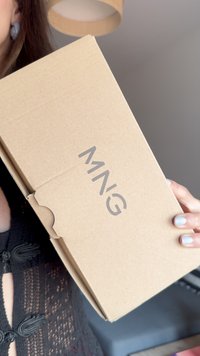 Brązowy kartonowy pudełko z przednim klapkiem, z napisem "MNG" wydrukowanym na szaro. Pudełko wygląda na proste i bez ozdób.