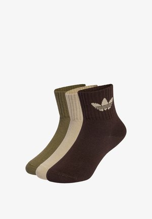 Tri parova čarapa do gležnja u smeđoj, maslinasto zelenoj i bež boji. Čarape imaju rebraste rubove i logo lista na smeđoj čarapi. Kvalitetan, mekani materijal i prilagođen dizajn.