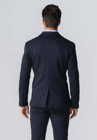 Mørkeblå skræddersyet blazer med en enkelt ventil bagpå, med en glat tekstur og knapmanchetter. Fremstillet af vævet stof, slankt design.