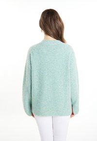 Maglione azzurro chiaro lavorato a maglia con una texture a coste, taglio oversize e scollo rotondo. Maniche lunghe e orlo dritto.